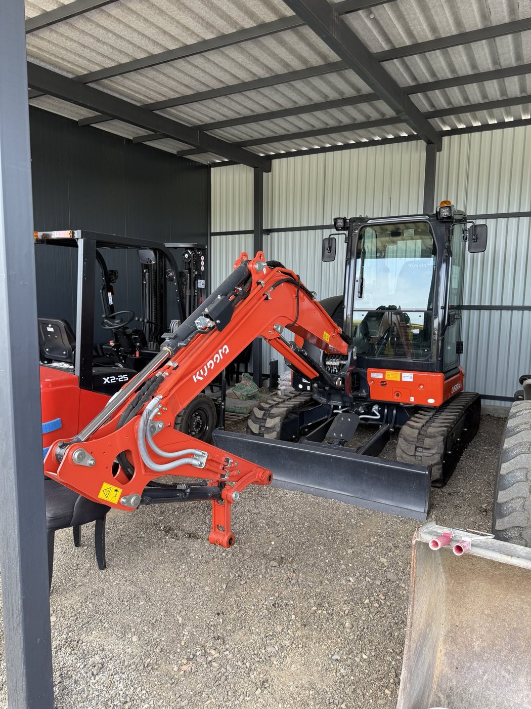 Kubota mini bager i viljuškar u hangaru